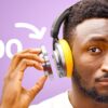 A picture of a young man wearing Dyson headphones on a purple backdrop.