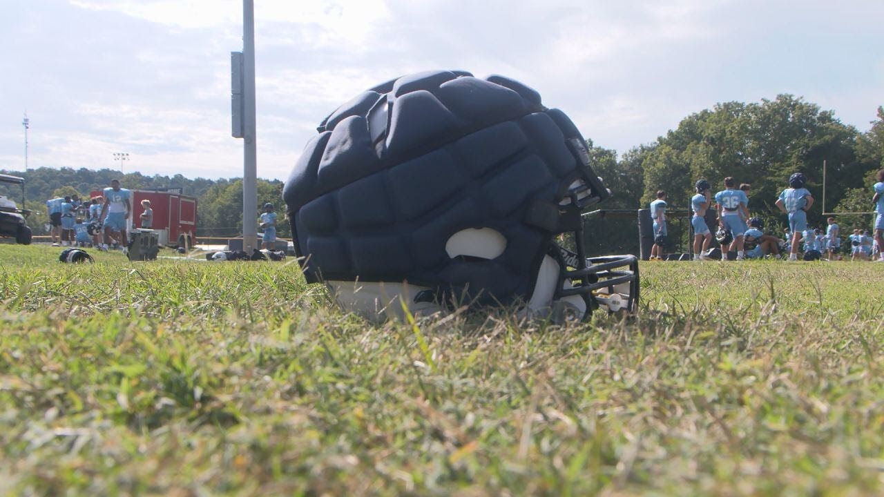 Football helmet equiped with Guardian Caps sitting on a field.