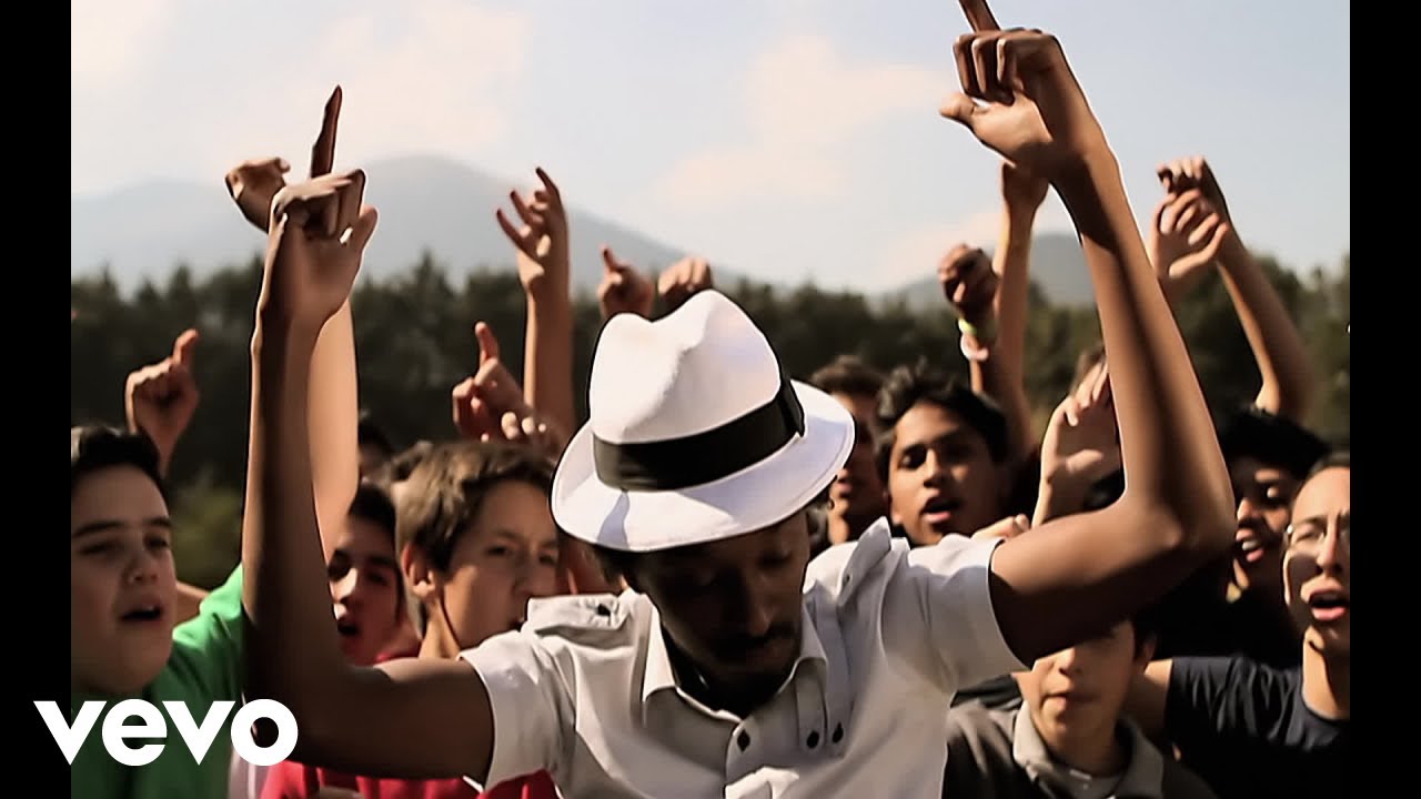 K'naan, pictured here in the Wavin' Flag music video, has been charged with sexual assault.