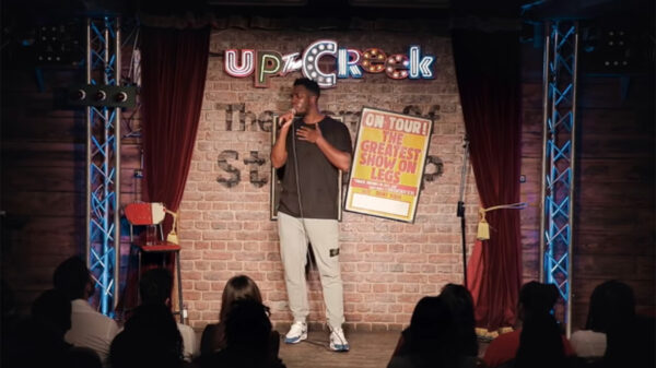 Comedian Mo Gilligan on stage performing a stand up routine.