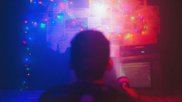 Conspiracists sitting in front of a wall full of photos and documents.