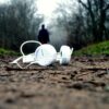 A person walking away from headphones left on the ground, an example of music anhedonia.