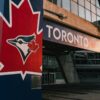 Entrance to the Toronto Blue Jays stadium featuring a large maple leaf logo, symbolizing national pride amid Canada-U.S. tensions.