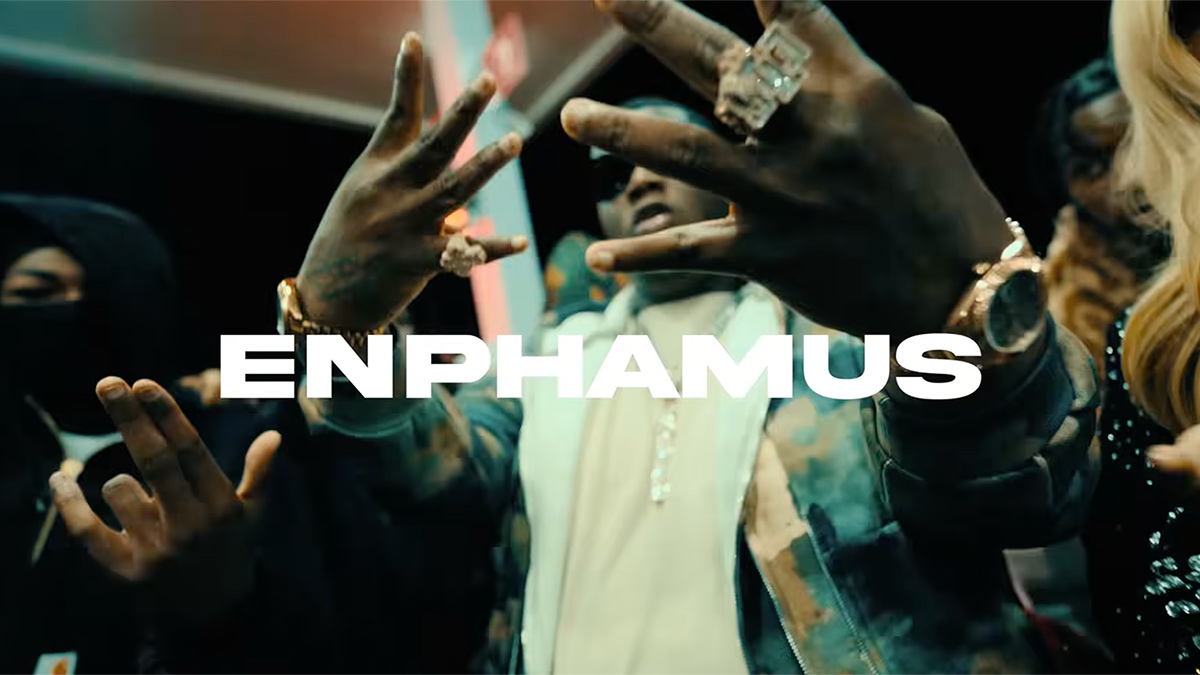 Enphamus throws up the W on his hand in a screengrab from his Live In a World music video.