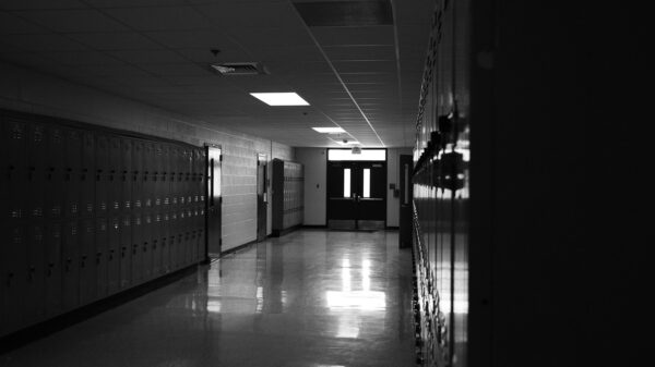 Empty school hallway with lockers and dim lighting, used to illustrate coverage of the Tumbler Ridge shooting.