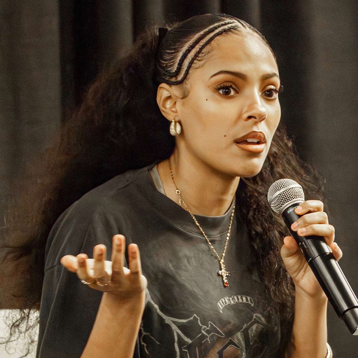 Artist Samara Cyn speaks into a microphone at a SXSW event.><br>
<span class=