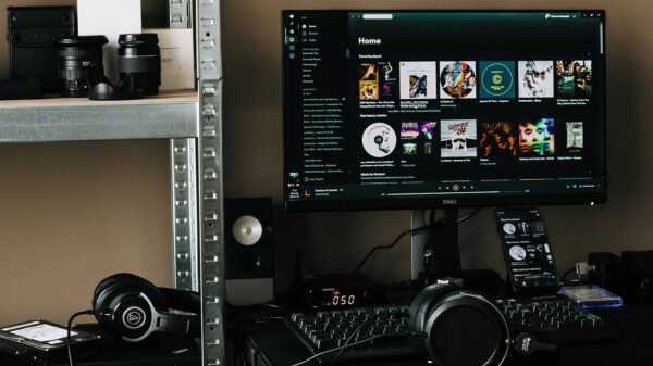 Desktop Spotify setup with headphones and speakers illustrating how Spotify AI influences Canadian music visibility.