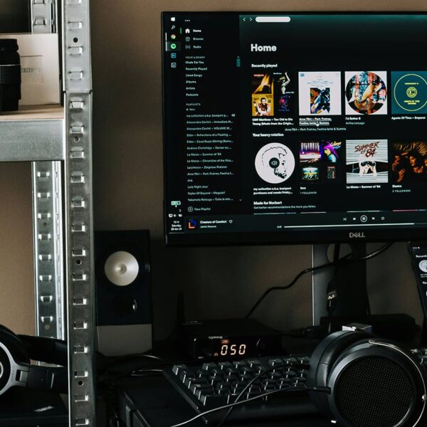 Desktop Spotify setup with headphones and speakers illustrating how Spotify AI influences Canadian music visibility.