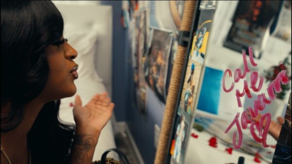 A woman looks into a mirror in a scene from the Hotboii music video Call Me Javarri.