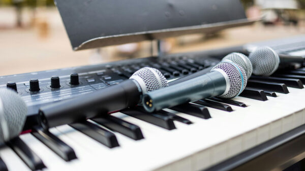 Several microphones resting on an electric keyboard.