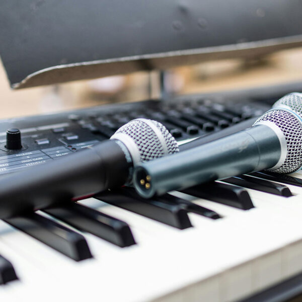 Several microphones resting on an electric keyboard.