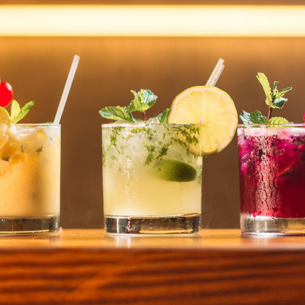Three mixed drinks on a bar illustrating alcohol use decline in Canada.