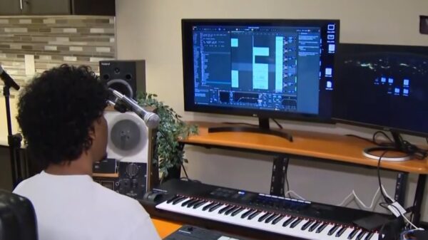 Producer ap.melodies looks at his computer in a scene from a news segment covering his connection to Drake.
