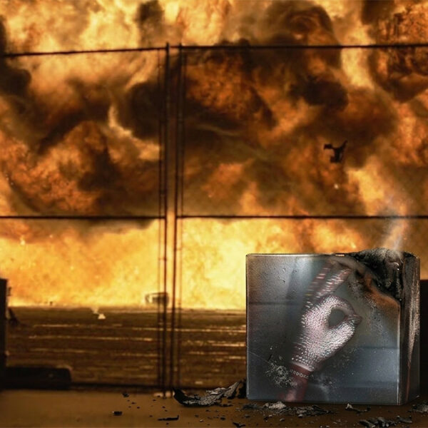 Drake HIM status concept image featuring album artwork printed on a scorched box with flames in the background.
