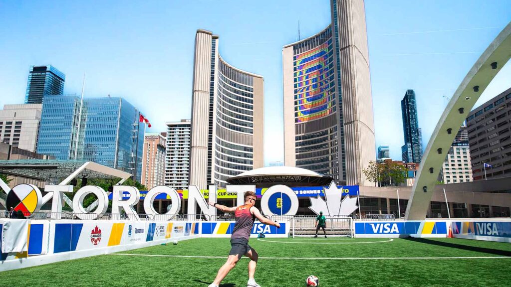 A vibrant soccer scene at Toronto City Hall with players on a sunny day.