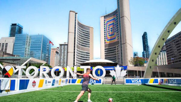A vibrant soccer scene at Toronto City Hall with players on a sunny day.
