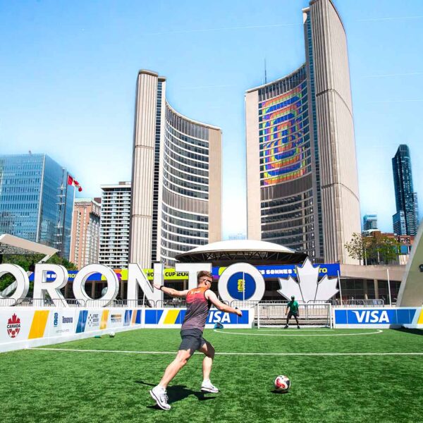 A vibrant soccer scene at Toronto City Hall with players on a sunny day.