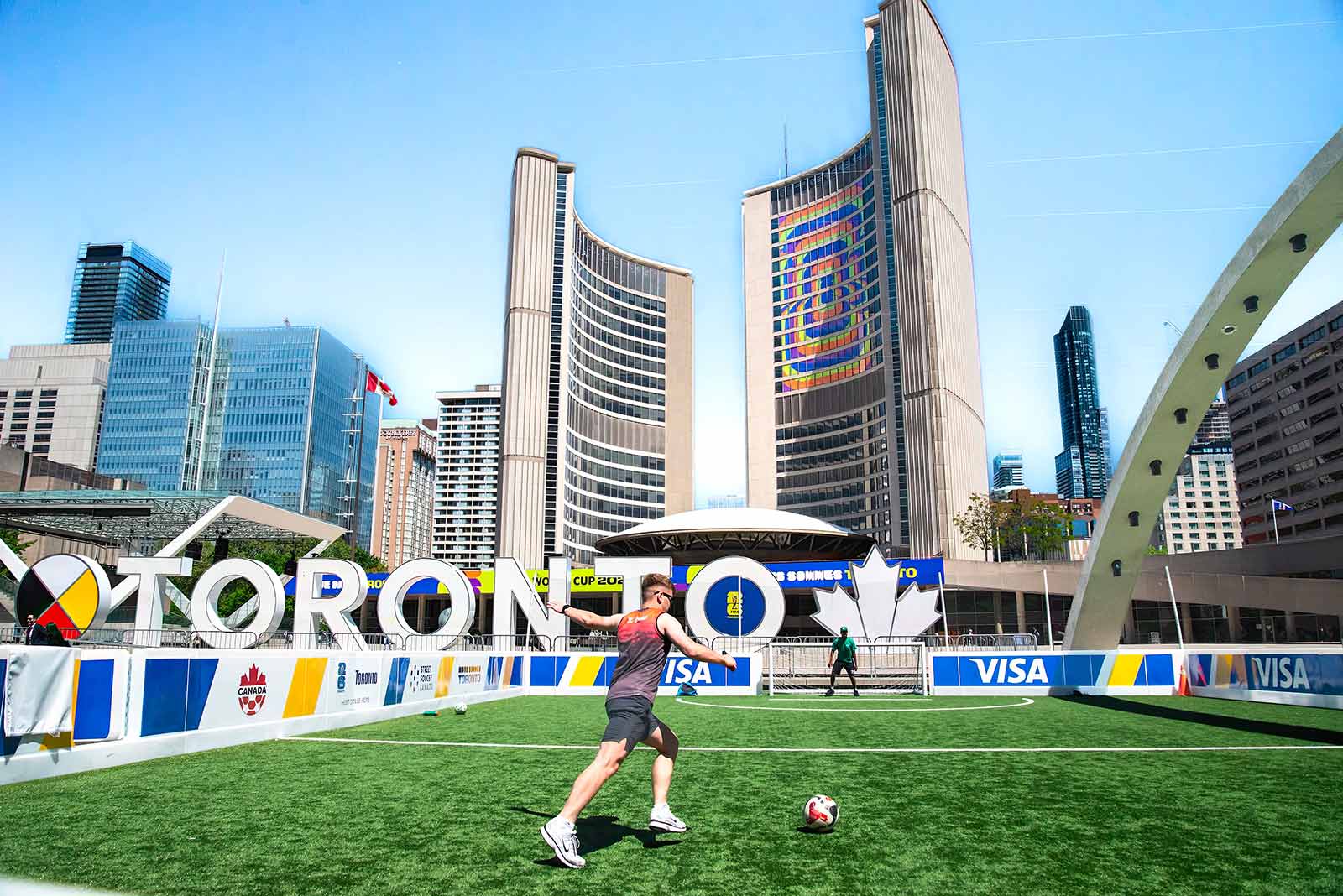 A vibrant soccer scene at Toronto City Hall with players on a sunny day.