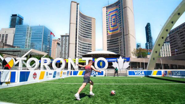 A vibrant soccer scene at Toronto City Hall with players on a sunny day.