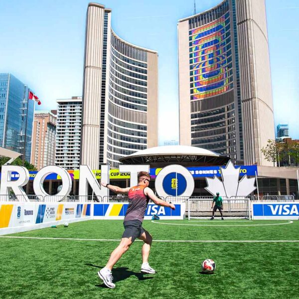 A vibrant soccer scene at Toronto City Hall with players on a sunny day.