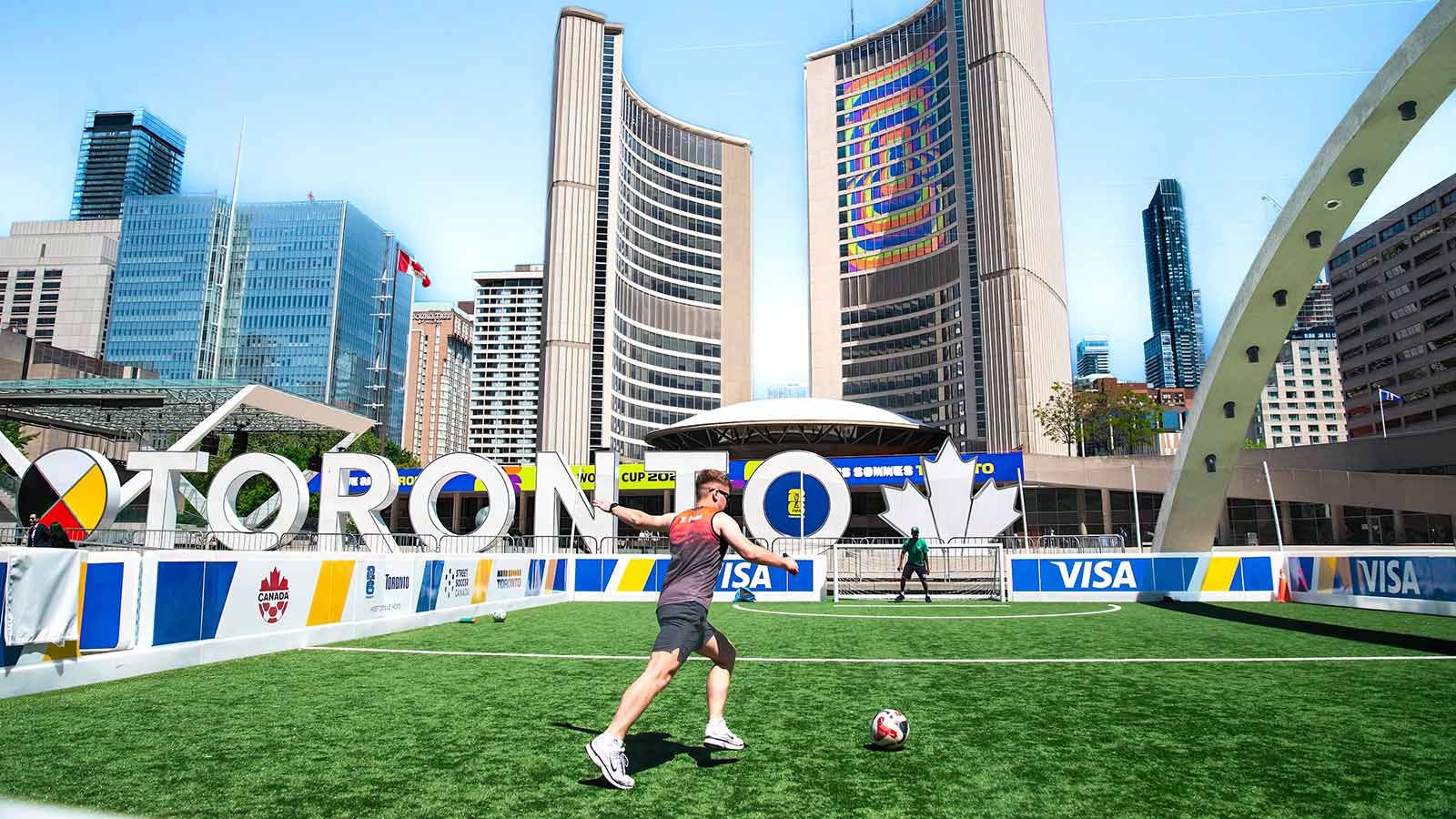 A vibrant soccer scene at Toronto City Hall with players on a sunny day.