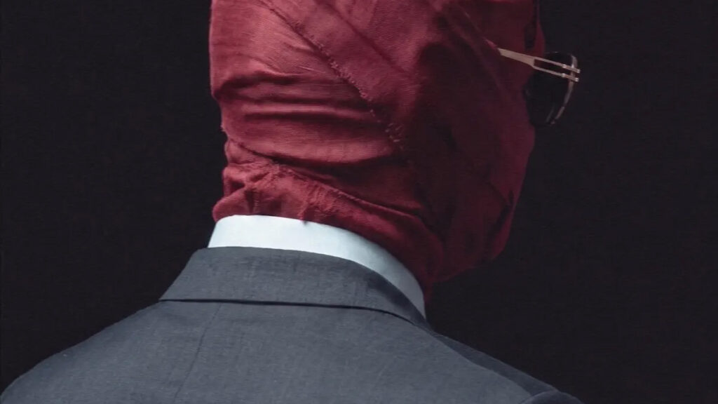 Man in suit wearing burgundy face covering, viewed from behind, representing the artwork for the new Tory Lanez album Made You Think I Was Gone ...But.