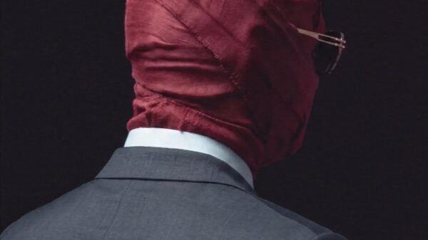 Man in suit wearing burgundy face covering, viewed from behind, representing the artwork for the new Tory Lanez album Made You Think I Was Gone ...But.