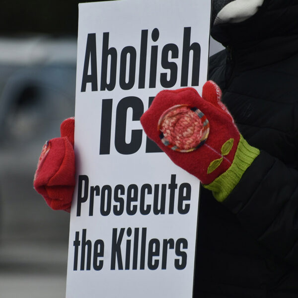 Person holding sign that says abolish ice, prosecute the killers.