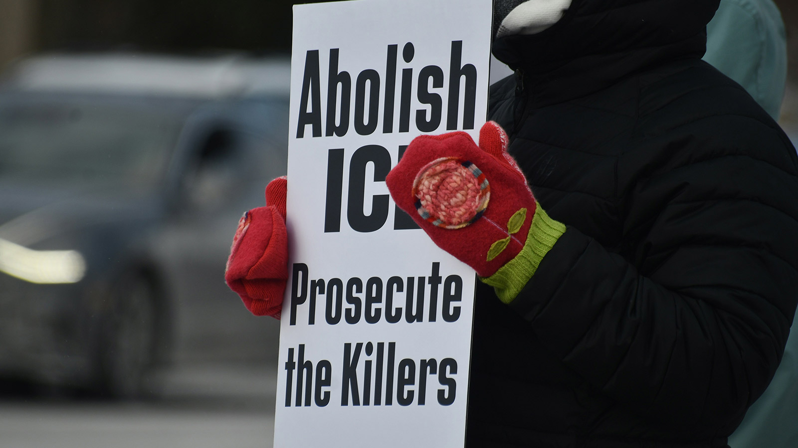 Person holding sign that says abolish ice, prosecute the killers.