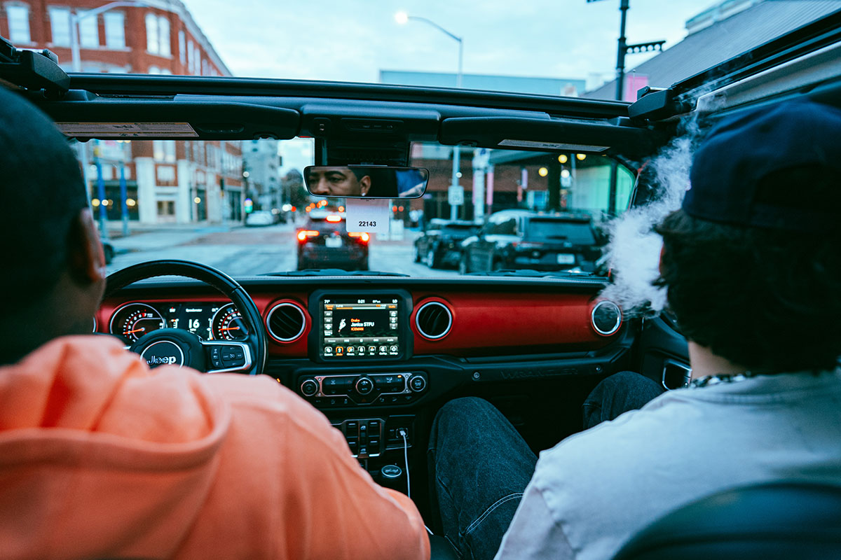 An over the shoulder view of two people driving in a car.