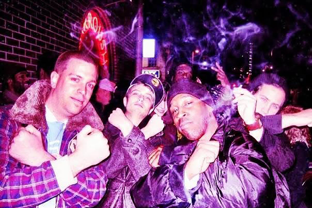 Mike Mikkelsen posing with three other people outside of a concert venue.